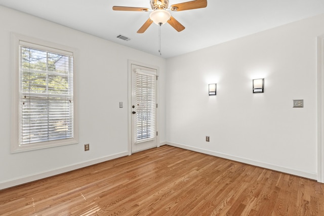 spare room featuring visible vents, ceiling fan, baseboards, and light wood-style floors