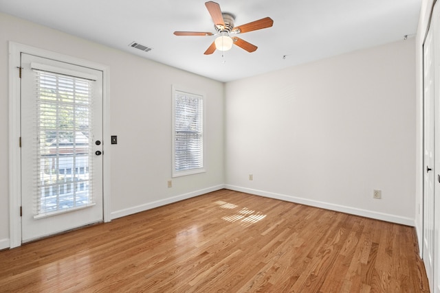 spare room featuring visible vents, light wood-style flooring, baseboards, and a ceiling fan