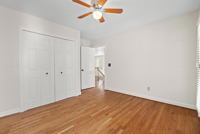 unfurnished bedroom with light wood-style floors, baseboards, a closet, and ceiling fan