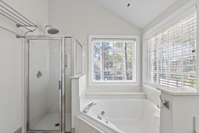 bathroom featuring a shower stall, a jetted tub, and vaulted ceiling