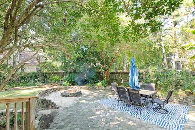 view of patio featuring outdoor dining space, a fire pit, and a fenced backyard