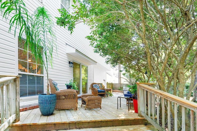 wooden terrace with outdoor lounge area and fence