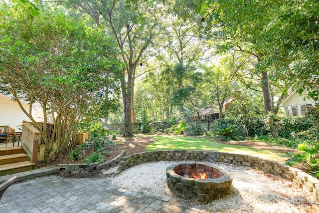 view of patio with a wooden deck and a fire pit