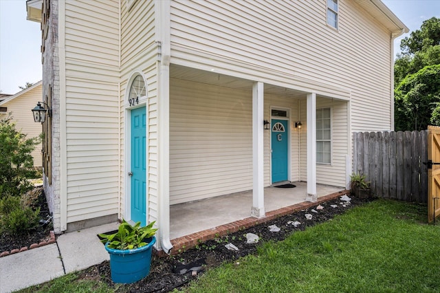 property entrance featuring fence and a lawn