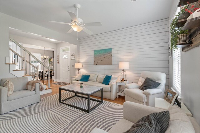 living room with light hardwood / wood-style flooring and ceiling fan with notable chandelier