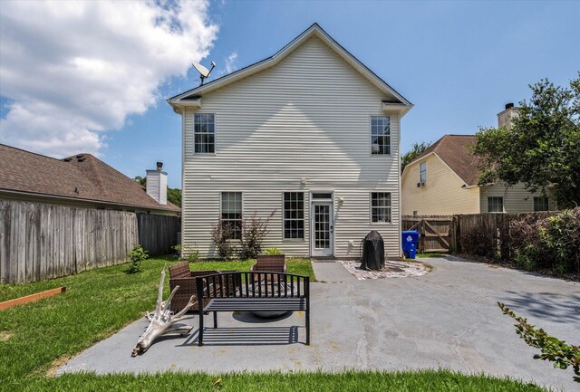 back of house featuring a lawn and a patio