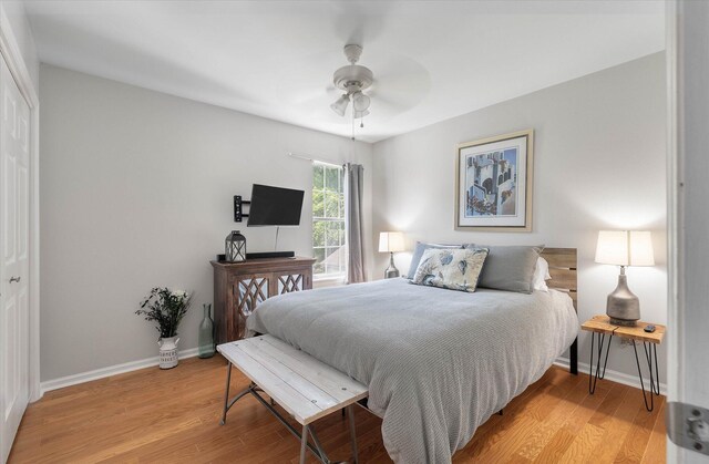 bedroom with light hardwood / wood-style flooring, ceiling fan, and a closet