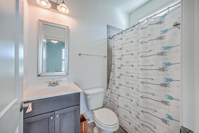 bathroom featuring walk in shower, vanity, toilet, and plenty of natural light