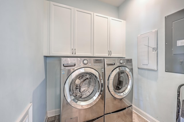 clothes washing area with washer and dryer, cabinets, and electric panel