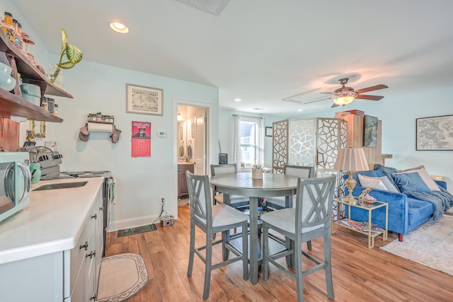 dining space featuring light wood-type flooring and ceiling fan