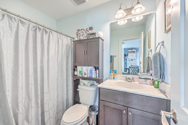 bathroom featuring vanity, toilet, and curtained shower