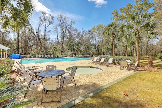 view of pool featuring a hot tub and a patio area