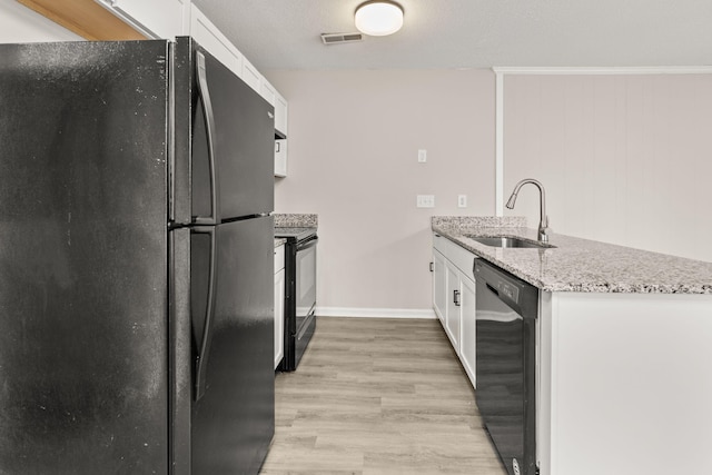 kitchen with light stone countertops, sink, white cabinets, and black appliances