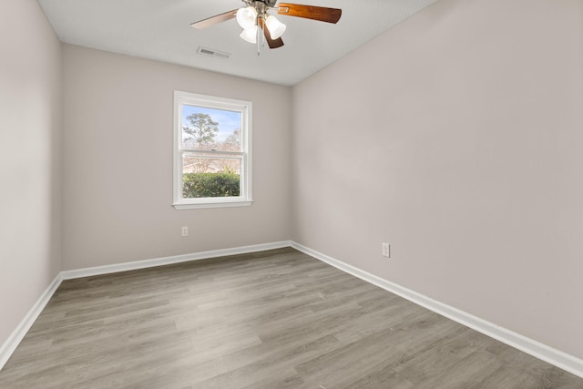 empty room with ceiling fan and light hardwood / wood-style flooring