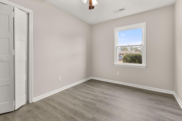 unfurnished bedroom with ceiling fan, light hardwood / wood-style flooring, and a closet