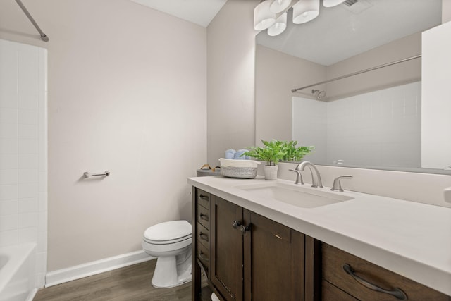 full bathroom featuring hardwood / wood-style flooring, vanity, toilet, and shower / bath combination