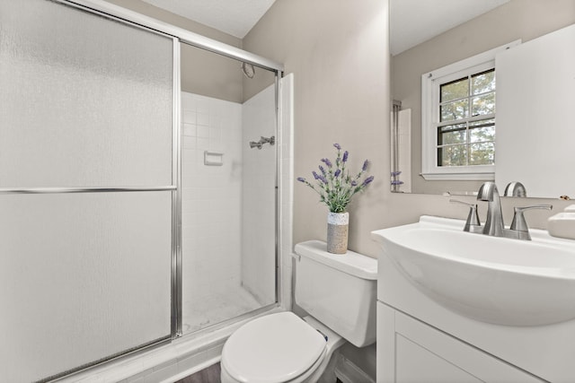 bathroom featuring vanity, an enclosed shower, and toilet