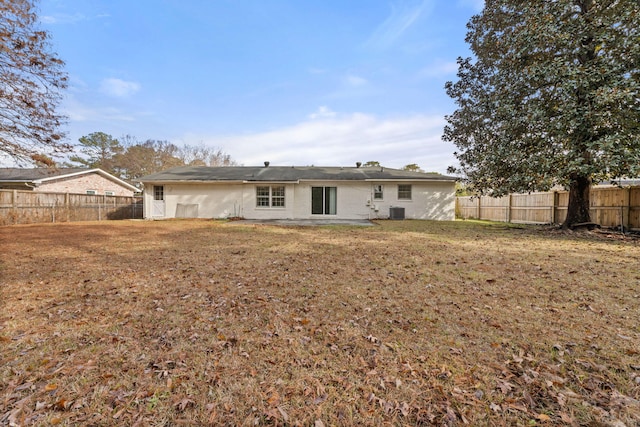 rear view of house featuring a lawn and central AC