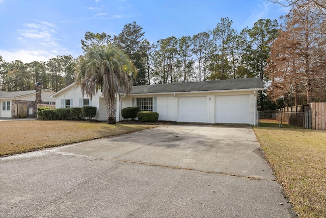 ranch-style home featuring a garage and a front lawn