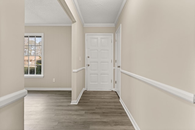 interior space with a textured ceiling, dark hardwood / wood-style floors, and ornamental molding