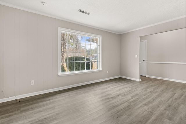 unfurnished room with hardwood / wood-style flooring, crown molding, and a textured ceiling