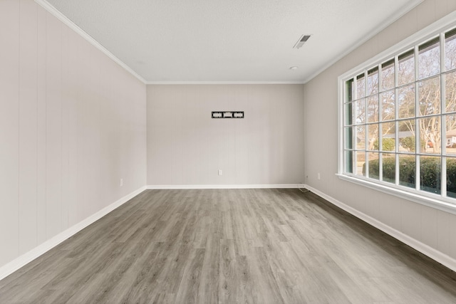 unfurnished room with hardwood / wood-style flooring, ornamental molding, and a textured ceiling