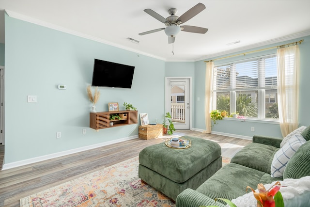 living room with ceiling fan, ornamental molding, and light hardwood / wood-style flooring