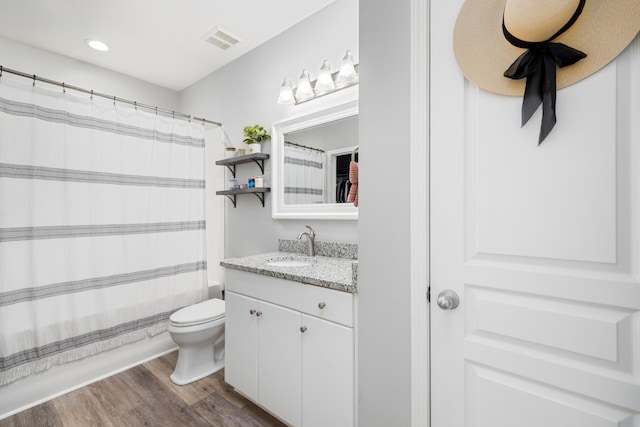 full bathroom with hardwood / wood-style floors, vanity, toilet, and shower / bathtub combination with curtain