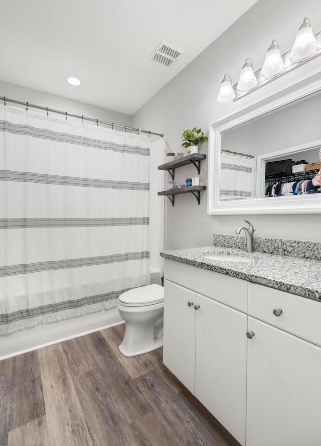 full bathroom with toilet, shower / bath combo with shower curtain, vanity, and hardwood / wood-style flooring