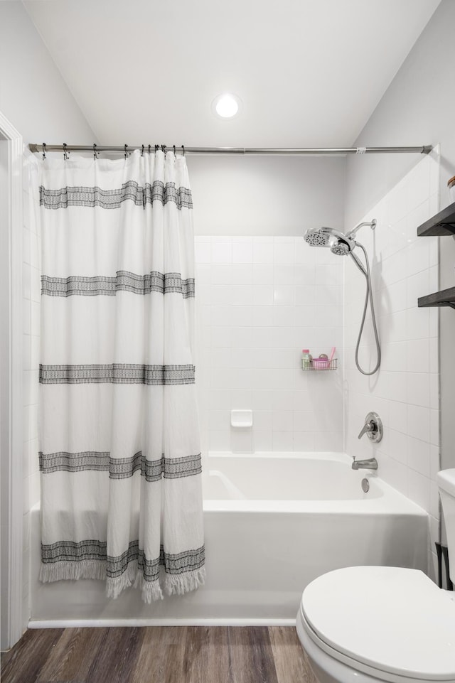 bathroom with hardwood / wood-style flooring, shower / bath combo, and toilet