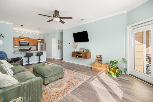 living room featuring light hardwood / wood-style flooring, ceiling fan, and ornamental molding