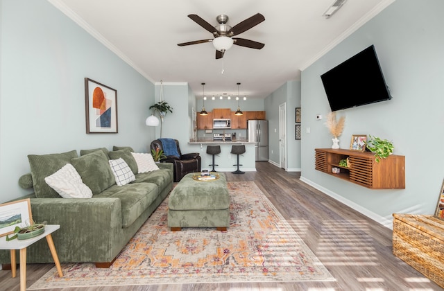 living room with crown molding, ceiling fan, and hardwood / wood-style flooring