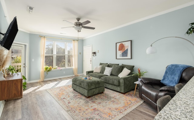 living room with light hardwood / wood-style flooring, ceiling fan, and ornamental molding