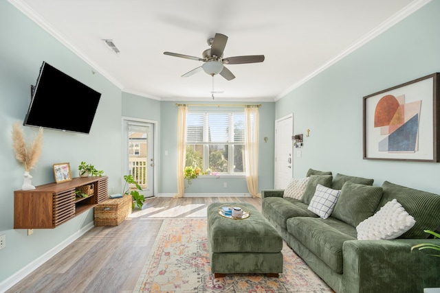 living room featuring crown molding, light hardwood / wood-style flooring, and ceiling fan