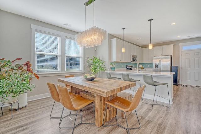 dining space featuring light wood-style flooring, visible vents, baseboards, and recessed lighting