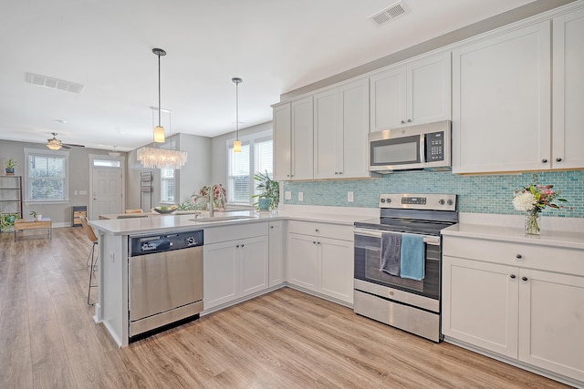 kitchen featuring stainless steel appliances, light countertops, visible vents, and a sink