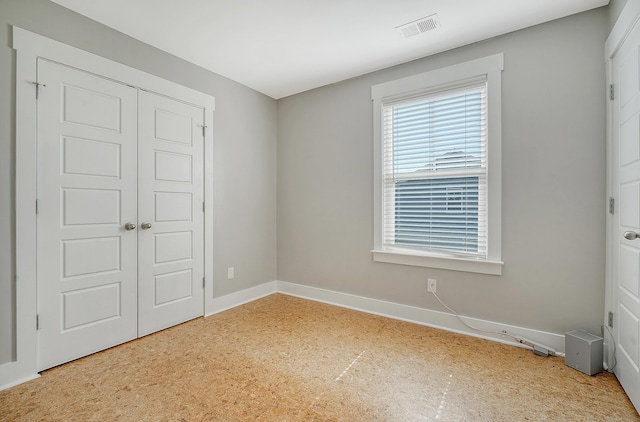 unfurnished bedroom with a closet, visible vents, and baseboards