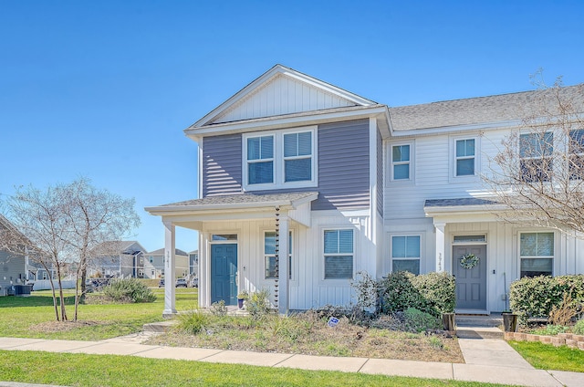 townhome / multi-family property featuring a front lawn, board and batten siding, and a shingled roof