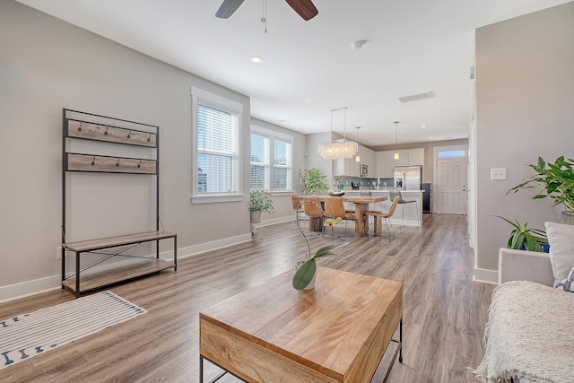 living area with light wood-type flooring, baseboards, and visible vents