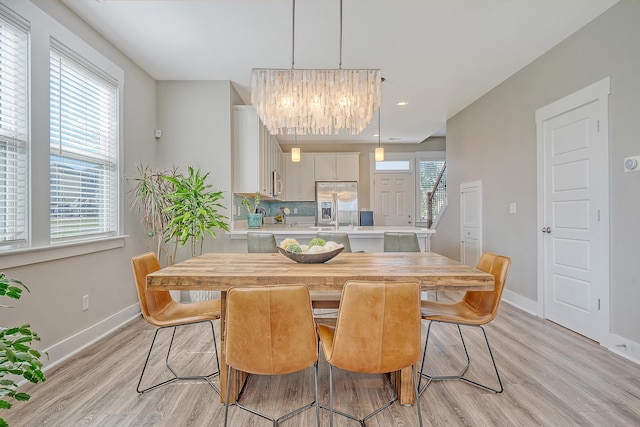 dining room featuring light wood-style flooring, baseboards, a chandelier, and recessed lighting