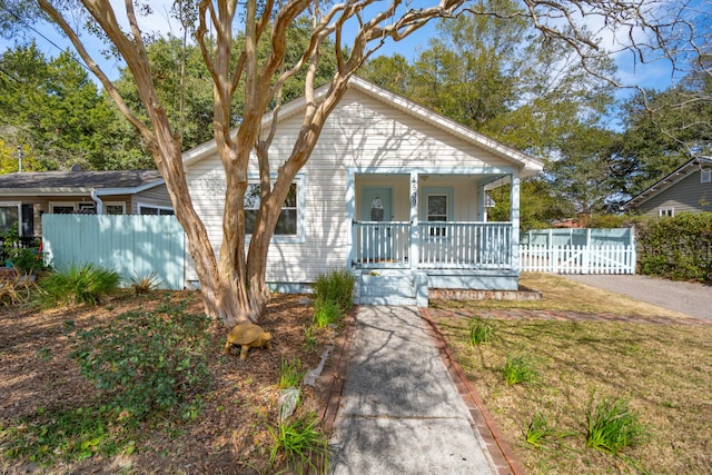 bungalow with a front lawn, fence, and a porch