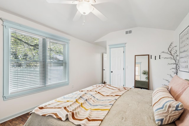 bedroom featuring vaulted ceiling, wood finished floors, visible vents, and a ceiling fan