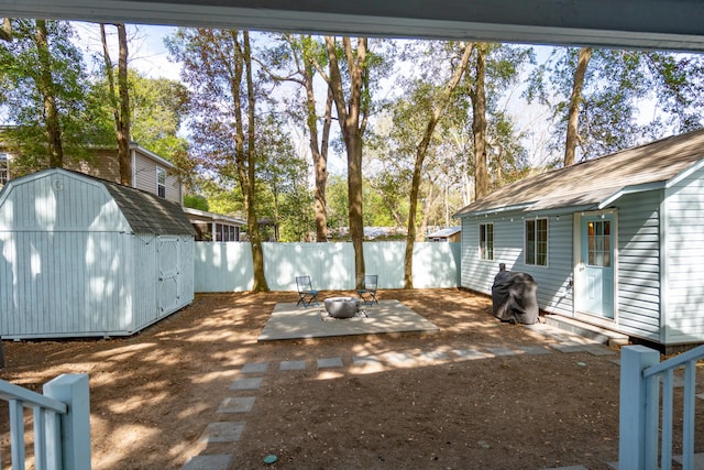 view of yard featuring an outbuilding, a storage unit, a patio area, and a fenced backyard