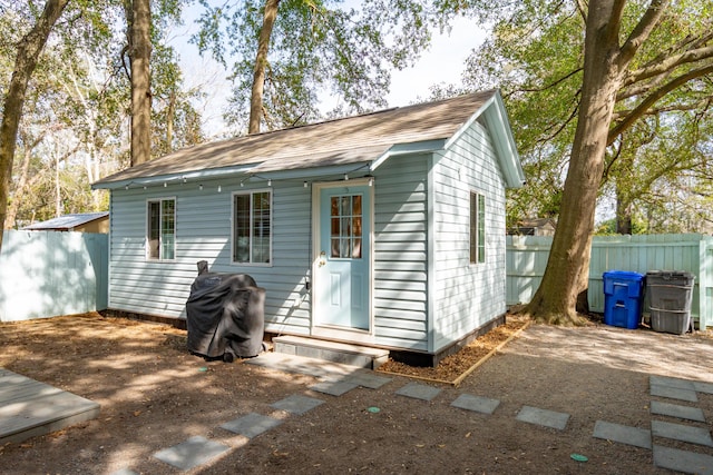 back of house with an outdoor structure and fence private yard