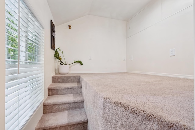 stairway with lofted ceiling, carpet floors, and baseboards