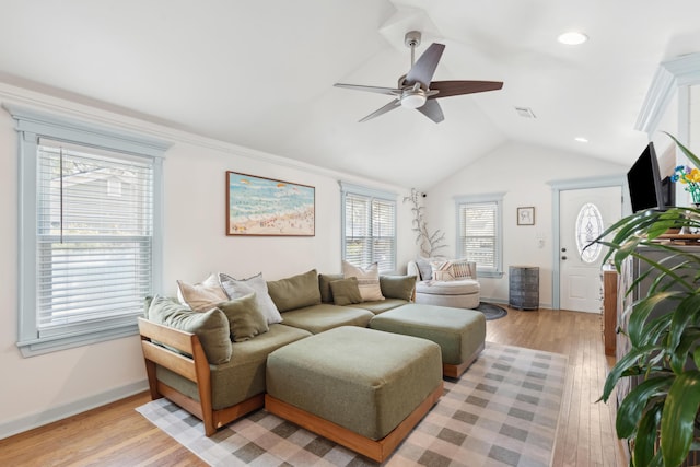 living area featuring lofted ceiling, baseboards, visible vents, and light wood finished floors