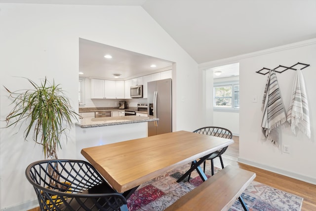 dining room with recessed lighting, vaulted ceiling, light wood-style flooring, and baseboards