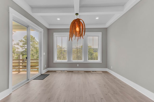 empty room featuring beamed ceiling, light hardwood / wood-style floors, and coffered ceiling