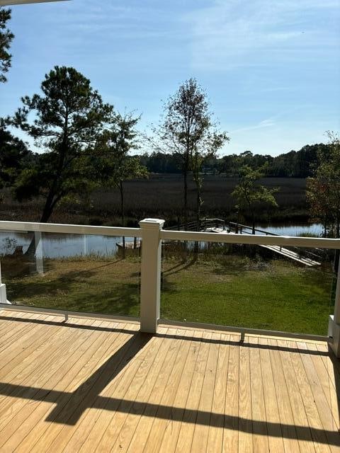 deck with a water view and a yard