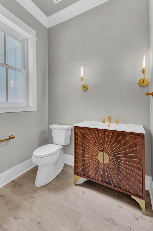 bathroom featuring toilet, ornamental molding, and sink